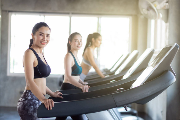 Groep van vrouwen uit te werken op loopband in sportschool doen cardio gewichtsverlies concept - Foto, afbeelding