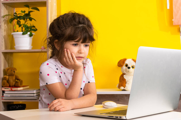 Distance or remote learning. Pupil want to sleep. Tired schoolgirl with hand on face sitting at laptop. Online school.  - Photo, Image