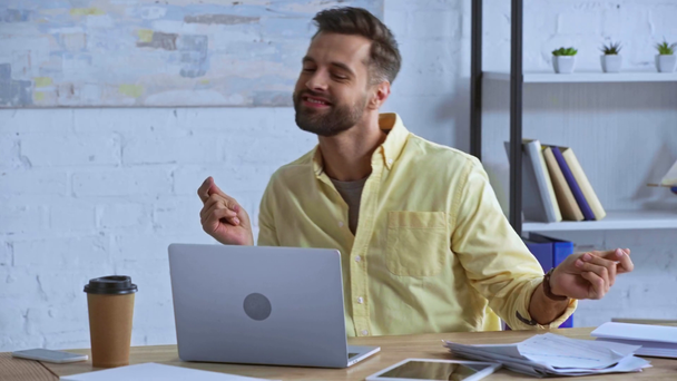 happy bearded businessman dancing near laptop  - Materiał filmowy, wideo
