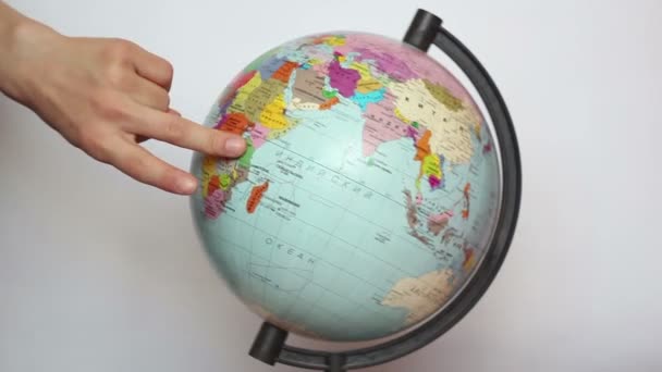 A female, hand with fingers steps on the earth globe. Beautiful female fingers walk around the globe, symbolizing a trip around the world. - Footage, Video
