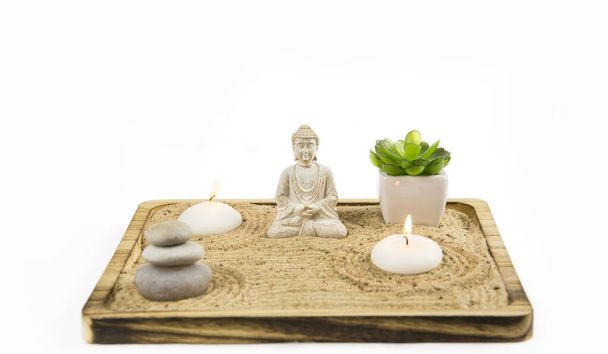 Мініатюрний стіл із Буддою у пісочниці сидять у кімнаті для тексту. Пісок - це відтворення природи. Свистячі візерунки на піску символізують воду, скелі - гори..  - Фото, зображення