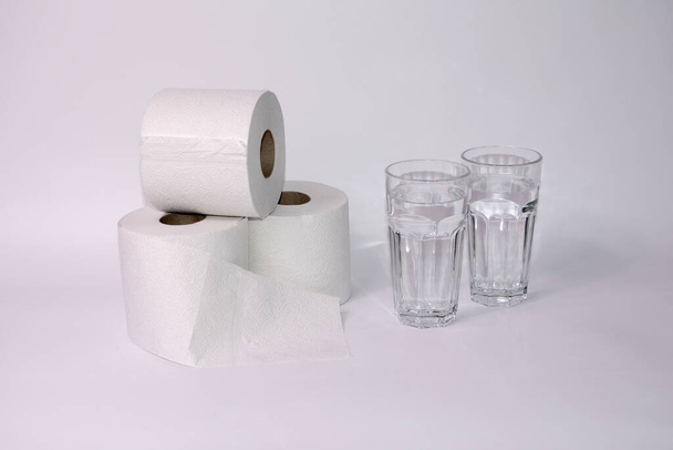 Dużo pić w przypadku biegunki - rolki papieru toaletowego z dwoma szklankami wody i z przestrzenią do kopiowania - Zdjęcie, obraz