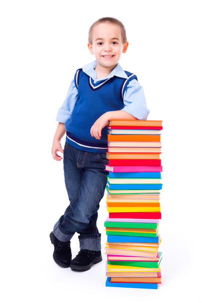 Little boy standing near stacked colorful books - Foto, Imagen