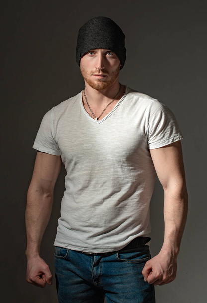 Man style and fashion. Brutal masculine man close up studio portrait. Handsome man with ginger red hair. Sexy ginger unshaven brutal man wearing beanie cap and white t-shirt. - Fotografie, Obrázek