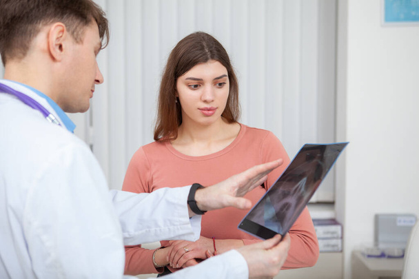 Männlicher Arzt untersucht Kernspintomographie seiner Patientin - Foto, Bild