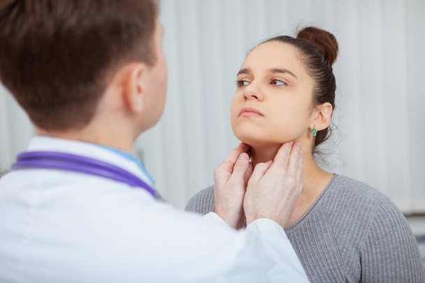 Schnappschuss einer jungen Frau, die im Krankenhaus vom Arzt an Hals und Hals untersucht wird. Virus, Grippe, Halsschmerzen - Foto, Bild