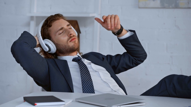 businessman with closed eyes listening music in headphones - Πλάνα, βίντεο