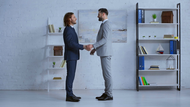 profile of happy businessmen in suits shaking hands  - Metraje, vídeo