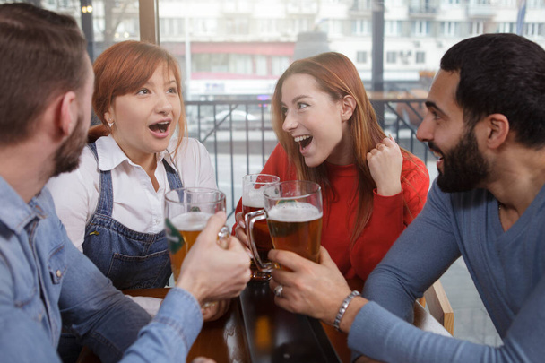 Gruppo di amici che parlano mentre bevono birra insieme al pub locale
 - Foto, immagini