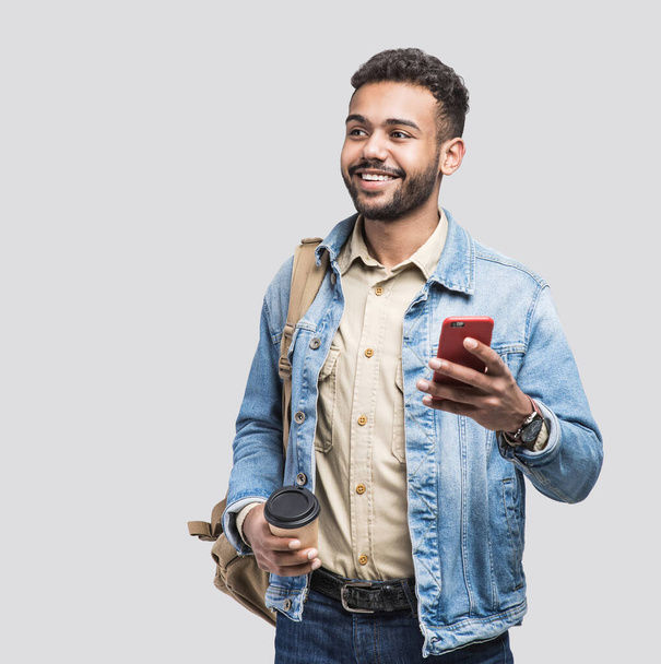 young handsome man with smartphone and coffee cup studio isolated portrait - Photo, image