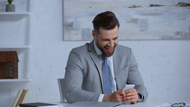 возбужденный и бородатый бизнесмен с помощью смартфона
  - Кадры, видео