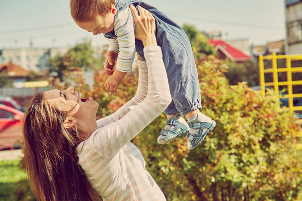 young mother playing with her baby. Mom and son outdoors. - 写真・画像