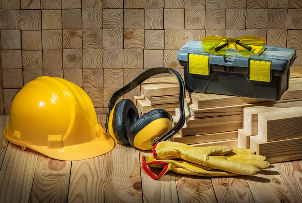 construction tools helmet gloves goggles earphones toolbox on wooden background - Photo, Image
