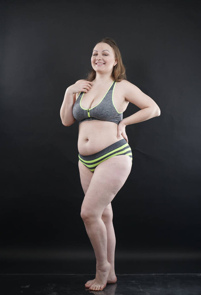 plus size woman shows her body in stretch marks and hair with cellulite and encourages you to love and accept yourself in any way . black background in the Studio. full length photo - Photo, image