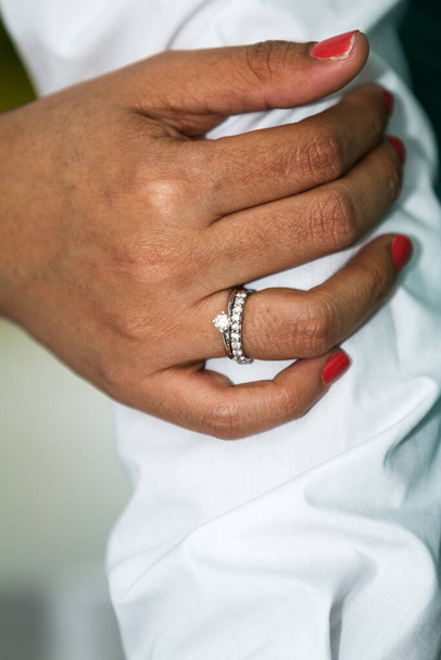 close up of the hands of a couple wearing their wedding bands - Foto, Imagen