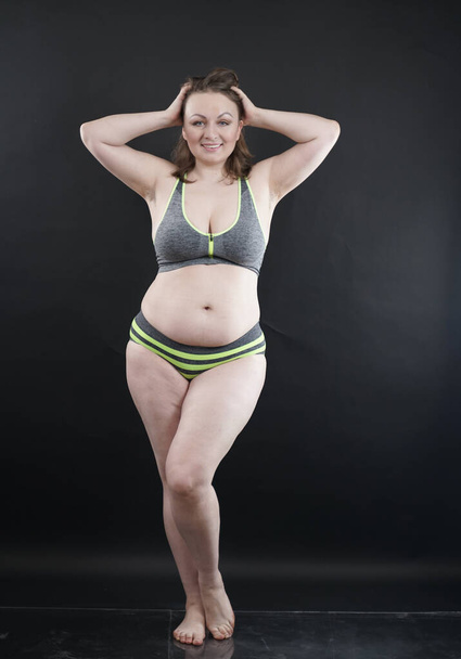 plus size woman shows her body in stretch marks and hair with cellulite and encourages you to love and accept yourself in any way . black background in the Studio. full length photo - Foto, Bild