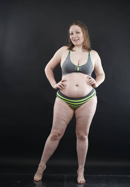 plus size woman shows her body in stretch marks and hair with cellulite and encourages you to love and accept yourself in any way . black background in the Studio. full length photo - Valokuva, kuva