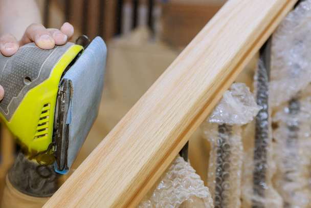 Lixamento de trilhos de madeira com lixa para trabalhos de moagem de escadas na madeira de madeira
 - Foto, Imagem