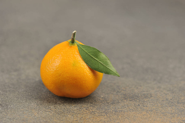 one ripe tangerine - whole tangerine with leave - close up - Foto, imagen