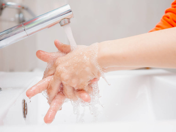obraz dłoni młodego chłopca podczas mycia, tylko ręce i umywalka, koncepcja higieny - Zdjęcie, obraz