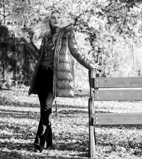 Lady attractive fashionista posing in jacket. Jacket for fall season concept. Woman fashionable blonde with makeup stand in autumnal park. Girl wear red bright warm jacket. Fall fashion concept - Photo, Image