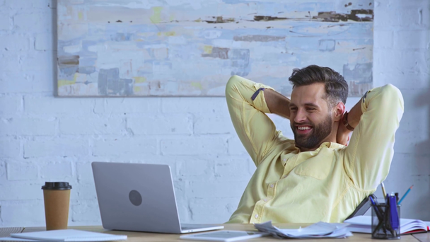 gelukkig zakenman op zoek naar laptop in de buurt van papieren beker - Video