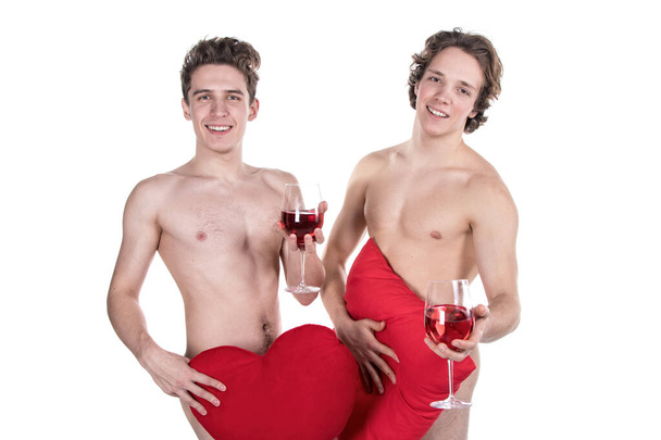 Two funny naked guys holding glasses with red wine and heart isolated on white - Fotó, kép