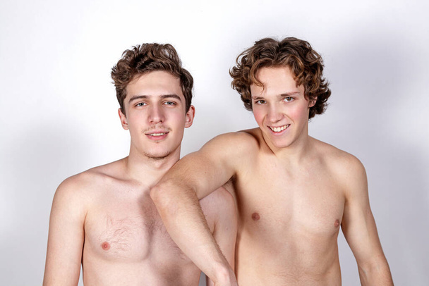 Two young sexy guys hugs on a white background - Fotó, kép
