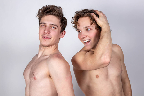 Two young sexy guys hugs on a white background - Foto, Imagen