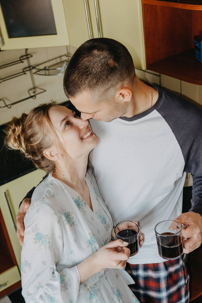 Valentine s Day at home. Romantic relationship quality time. Couple slow day spent indoors, drinking coffee and hugging in kitchen. - Фото, зображення