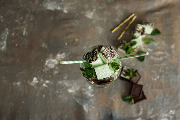 Mint and delicious marshmallows in a beautiful glassy glass with sprigs of fresh mint. Cocktail of marshmallows - Photo, Image