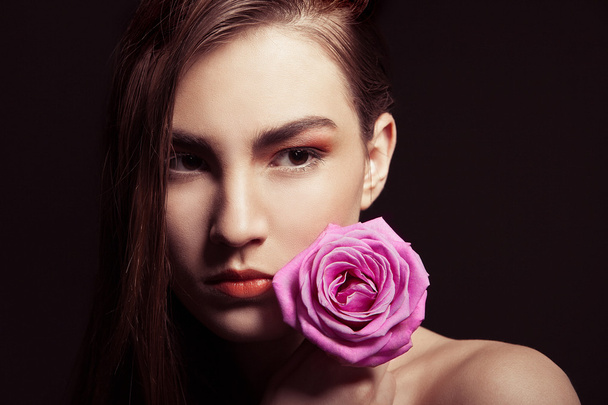 Portrait of beautiful brunette woman with rose - Photo, image