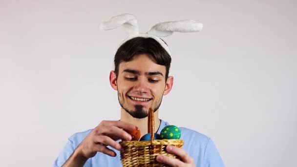 Uova di Pasqua. Un ragazzo con le orecchie e un uovo di Pasqua in mano. Pasqua. Su sfondo bianco
 - Filmati, video