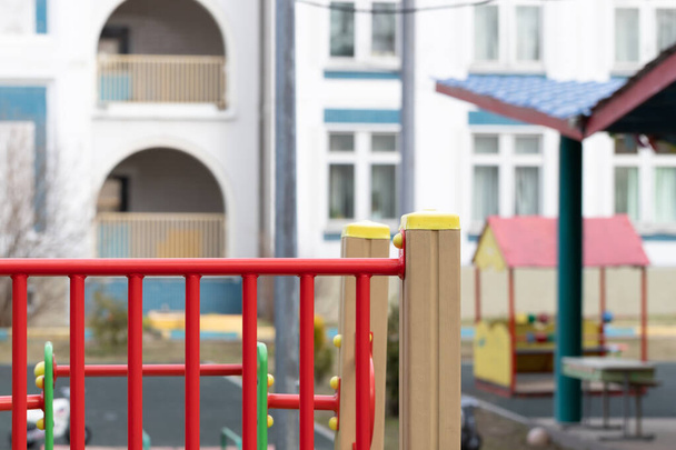 Um parque infantil vazio em um jardim de infância moderno em um dia de primavera ensolarado. Área de segurança fechada para jogos ao ar livre para crianças. Foco seletivo, espaço de cópia para o seu texto
. - Foto, Imagem