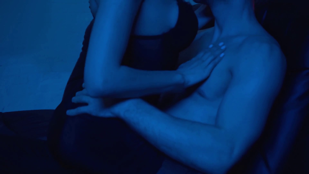 przystojny mężczyzna całuje uwodzicielski młoda kobieta na niebieski - Materiał filmowy, wideo