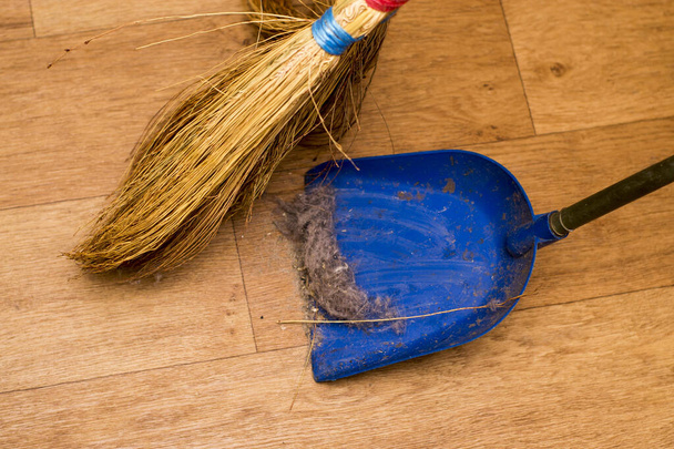 Close-up of dustpan and sweeping broom on wooden floor - Zdjęcie, obraz
