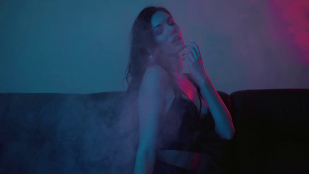 focus pull of sexy girl in lingerie sitting on blue with smoke - Footage, Video