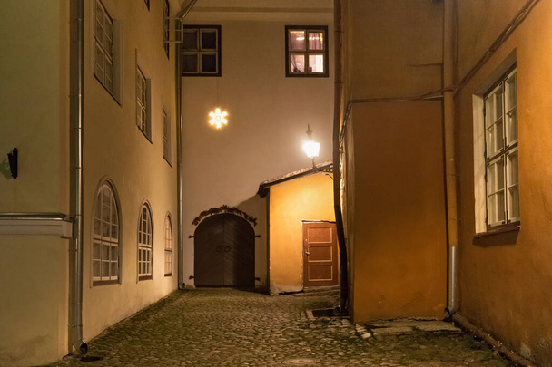 Night view of the old courtyard in the historical part of Tallinn. The city is the capital and the most populous city of Estonia.  - Foto, afbeelding