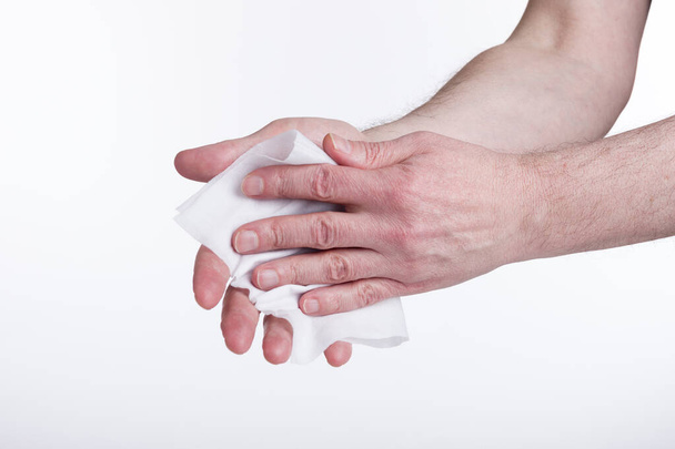 Human hands use a wet wipe close-up on a white background. Concept of infection. - Photo, Image