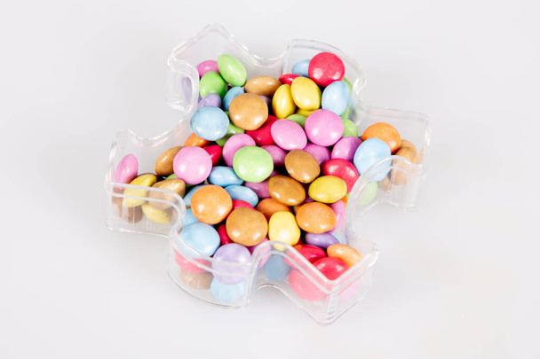 Monet monivärinen lasitettu suklaa karkkeja muovi laatikko karkkia kontti valkoinen tausta
 - Valokuva, kuva