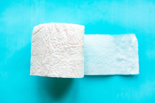 Rollo de papel higiénico suave y blanco sobre fondo azul. Concepto de higiene
.  - Foto, Imagen