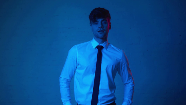 hombre guapo en traje tocando el pelo en azul
 - Metraje, vídeo