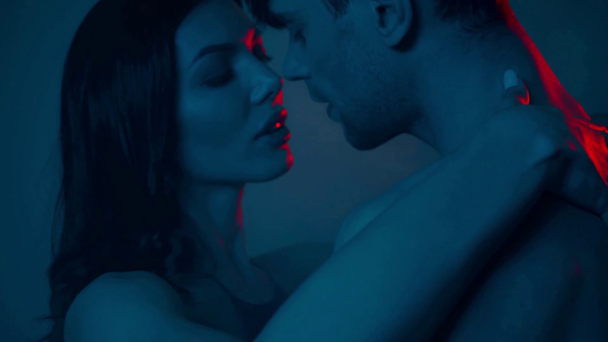 sensual woman touching shirtless man on blue with smoke - Footage, Video