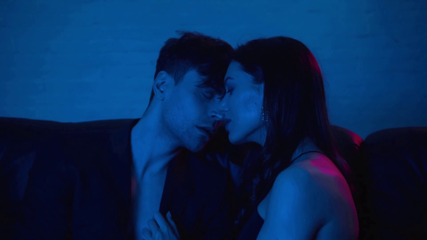 sexy Paar berührt Nasen und sitzt auf blau  - Filmmaterial, Video