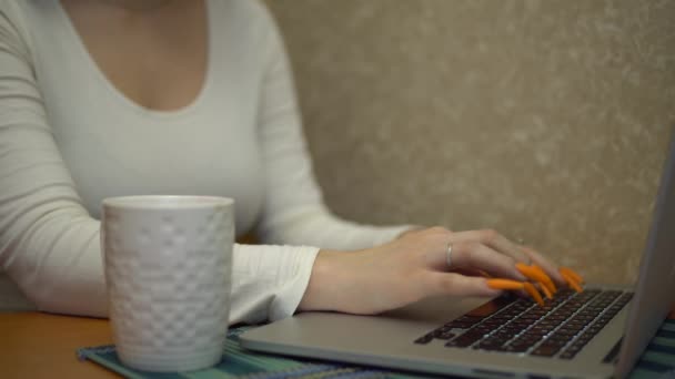 Giovane donna che lavora su laptop in cucina digitando sul taccuino mockup bere il tè
 - Filmati, video