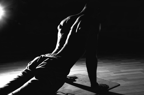 Modèle de remise en forme exercice assis se lève et croque. Musclé bien construit, corps tonique avec six pack transpiration
.  - Photo, image