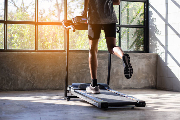 Young men exercise on an automatic treadmill - Fotó, kép