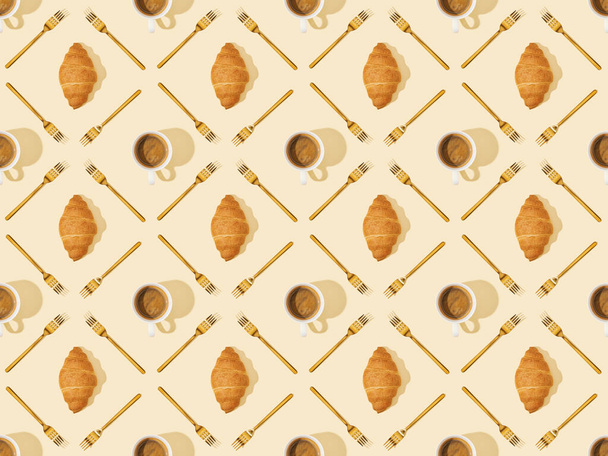 Ansicht von goldenen Gabeln, Croissants und Kaffee auf beigem, nahtlosem Hintergrundmuster - Foto, Bild