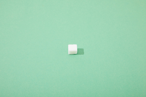 lump sugar cube on green background with copy space - Foto, imagen