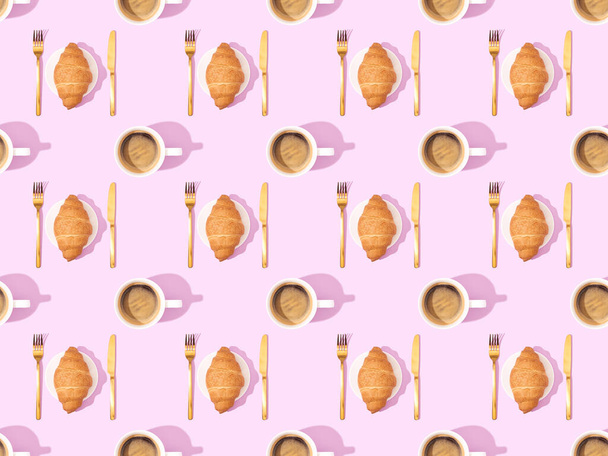 top view of cutlery, croissants on plates and coffee on pink, seamless background pattern - Photo, Image